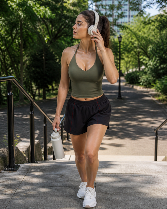 Red Monté moss green halter tank and black athletic shorts styled on shaded park stairs