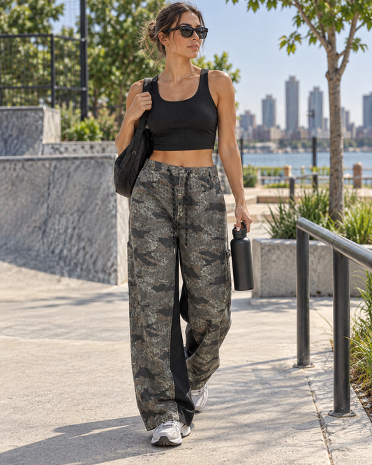 Red Monté leopard-camo cargo pants styled with a black sports crop for an outdoor city walk