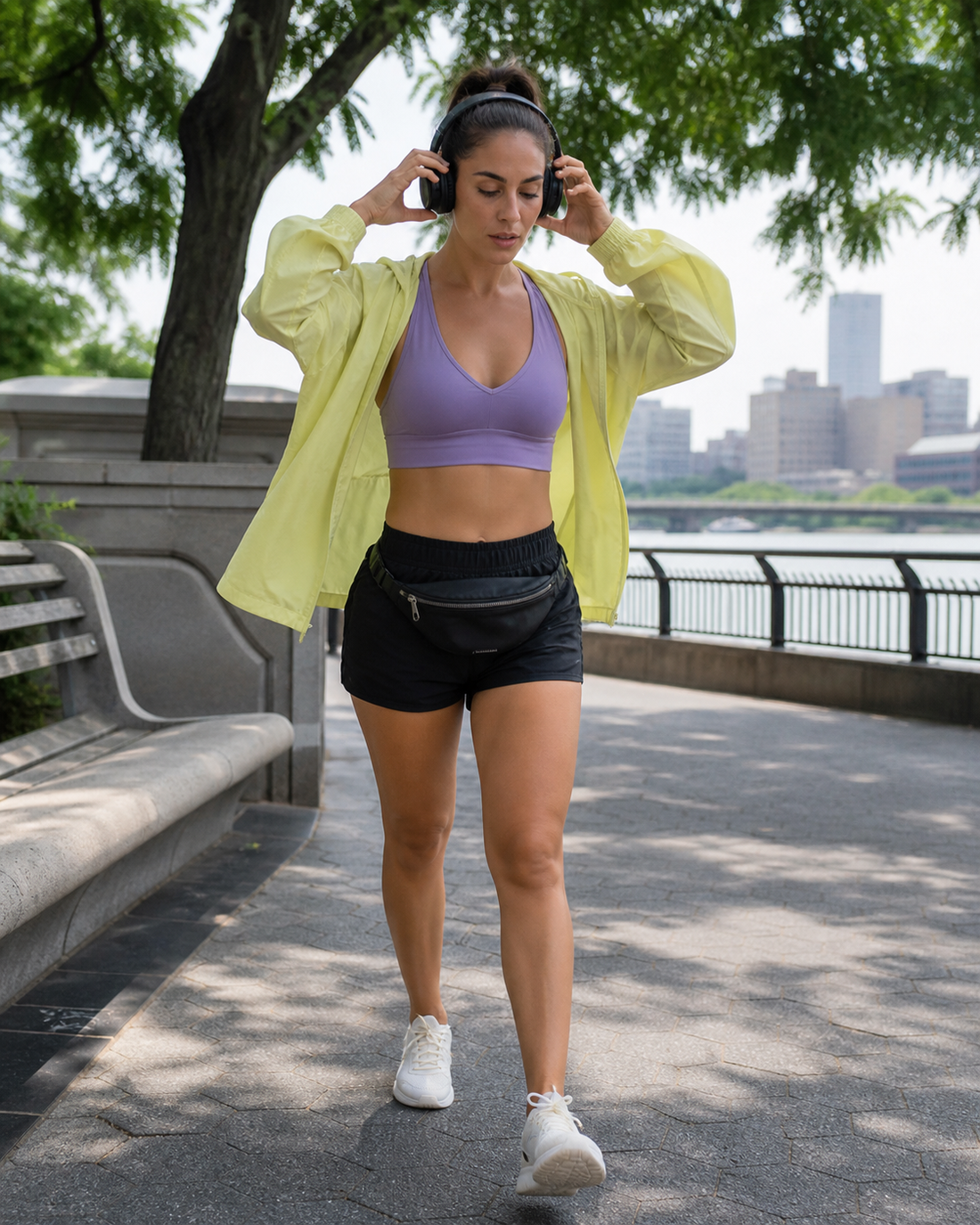 Red Monté lilac active top, lemon hooded jacket, and black athletic shorts styled on a shaded city walking path